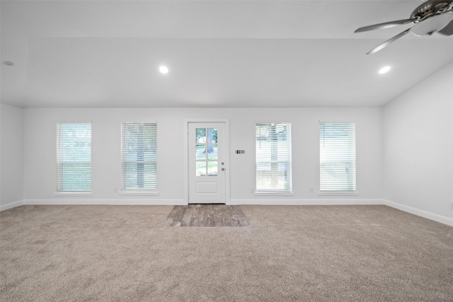 interior space with ceiling fan, light colored carpet, and lofted ceiling