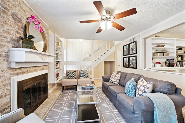 living room with built in features, a textured ceiling, and a fireplace