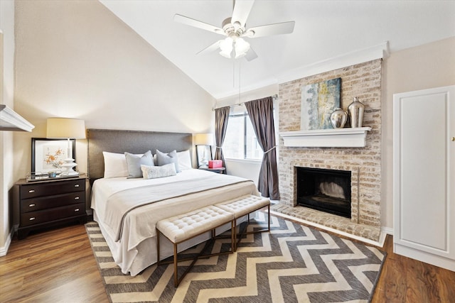 bedroom featuring hardwood / wood-style floors, a fireplace, high vaulted ceiling, and ceiling fan