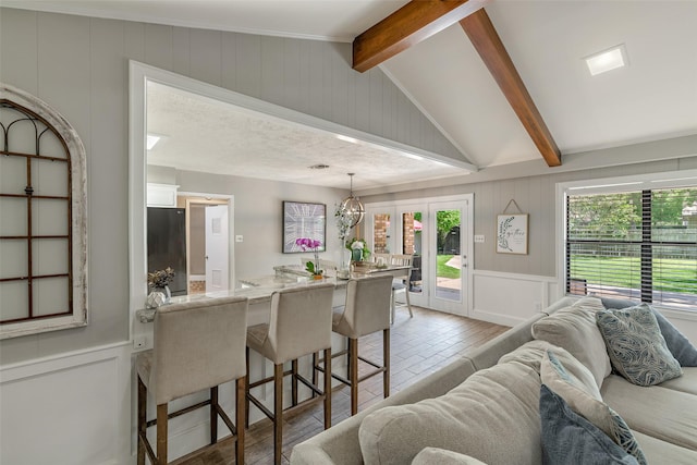 kitchen with vaulted ceiling with beams, a kitchen bar, plenty of natural light, and pendant lighting