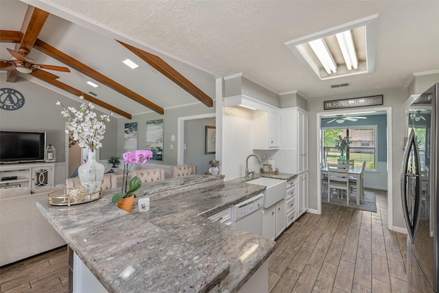 kitchen with sink, white cabinets, stainless steel refrigerator, and kitchen peninsula