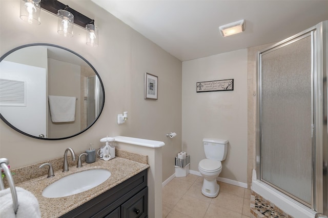 bathroom featuring toilet, a shower with door, vanity, and tile patterned floors