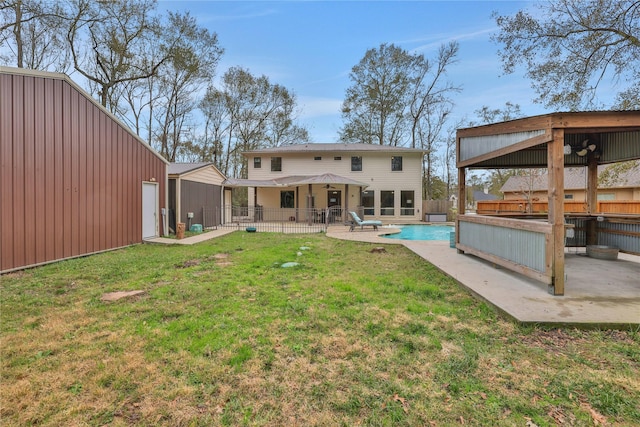 back of house with a patio area and a lawn