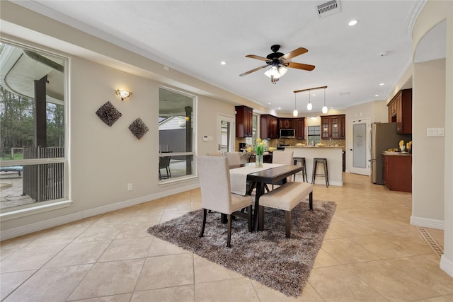 dining room with light tile patterned flooring, ceiling fan, and ornamental molding