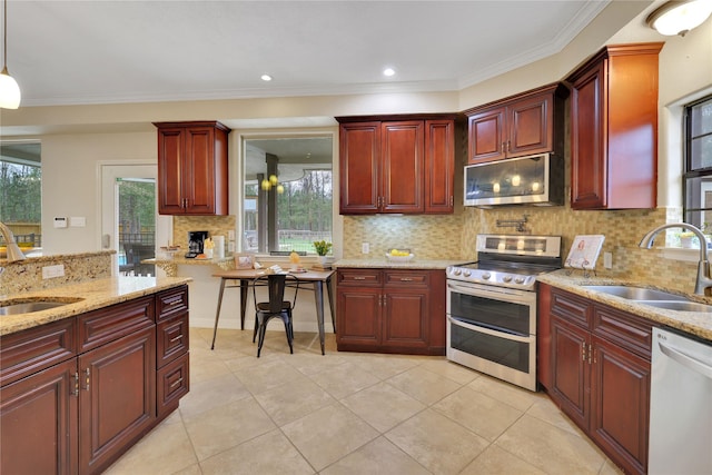 kitchen with sink, stainless steel appliances, hanging light fixtures, and tasteful backsplash