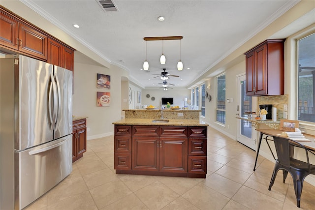 kitchen featuring light tile patterned floors, sink, ornamental molding, pendant lighting, and stainless steel fridge