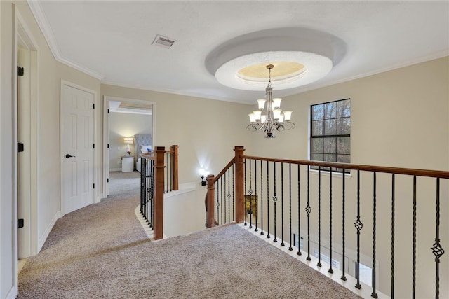 hall with a notable chandelier, light colored carpet, and ornamental molding