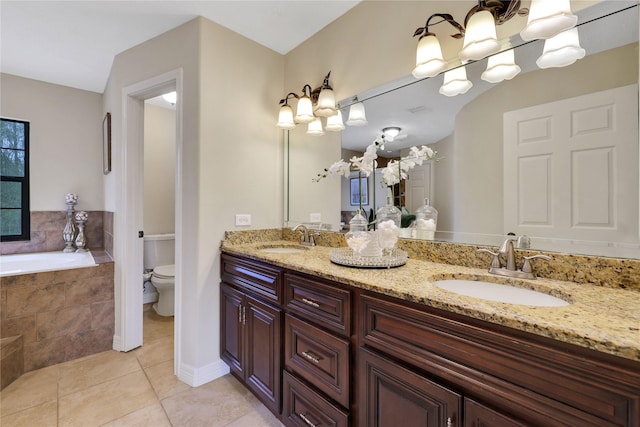 bathroom featuring tiled tub, toilet, vanity, and tile patterned flooring