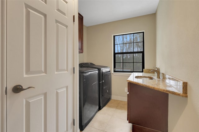 clothes washing area featuring cabinets, sink, independent washer and dryer, and light tile patterned flooring