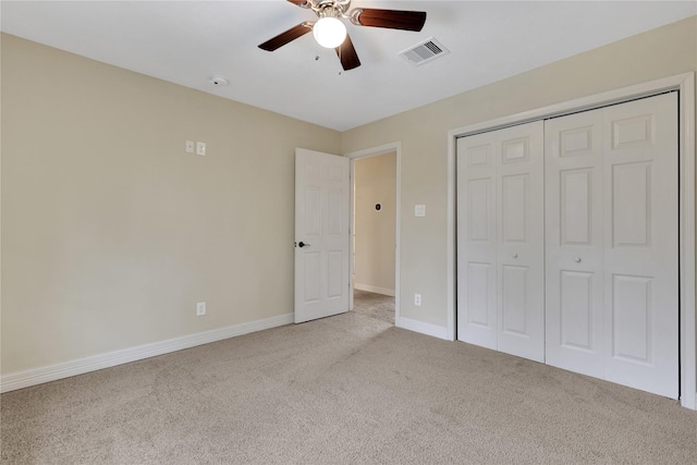 unfurnished bedroom featuring ceiling fan, a closet, and light carpet