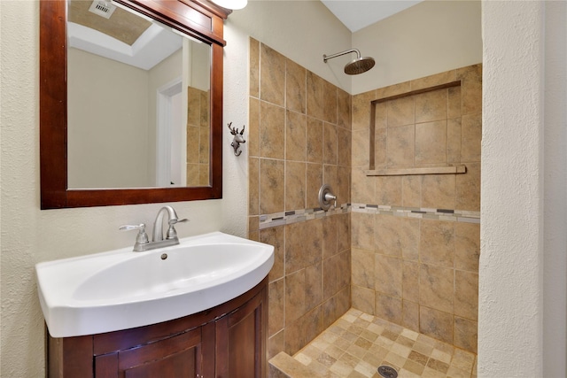 bathroom featuring vanity and tiled shower