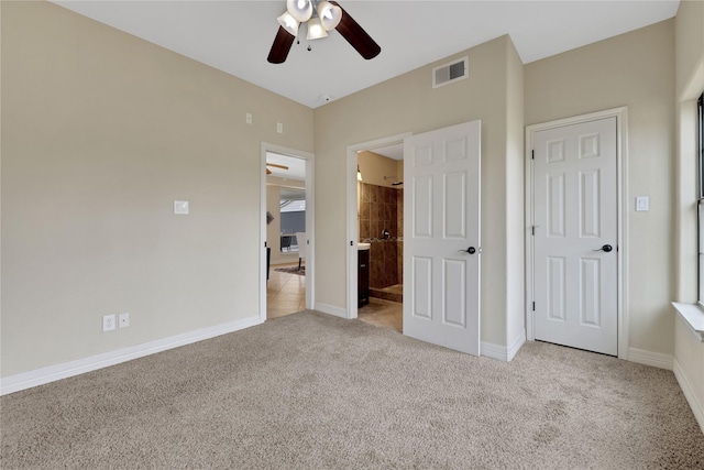 unfurnished bedroom with ceiling fan, connected bathroom, and light carpet