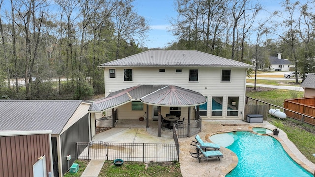 rear view of house featuring a pool with hot tub and a patio area