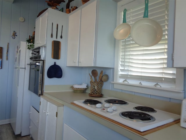 kitchen featuring white cabinetry and white appliances