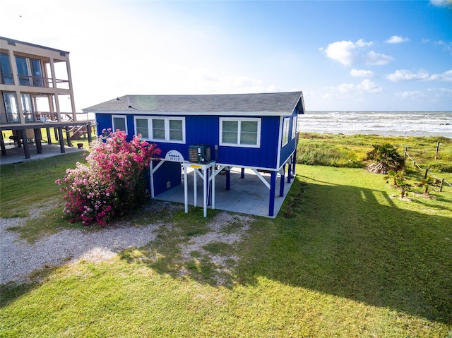 rear view of property with a water view, a yard, a patio area, and central air condition unit