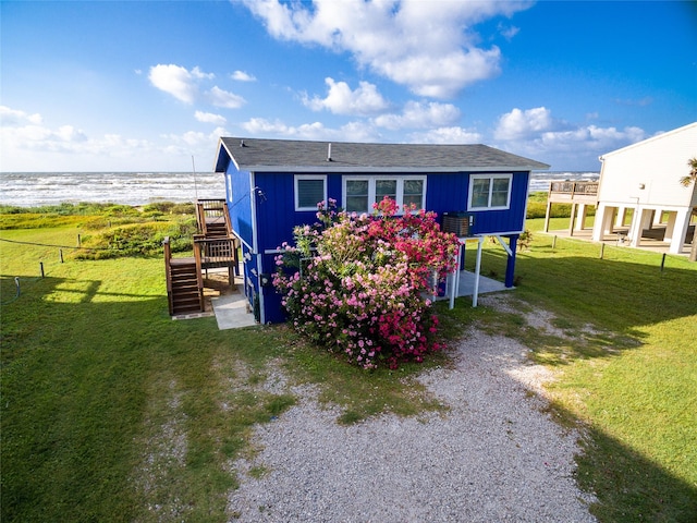 exterior space with a water view and a front yard