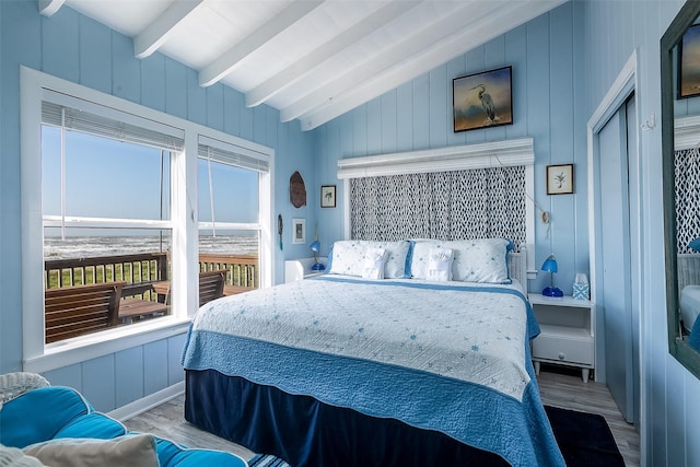 bedroom featuring wood-type flooring and lofted ceiling with beams