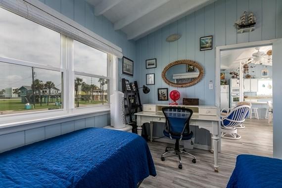 bedroom with wood-type flooring and vaulted ceiling with beams