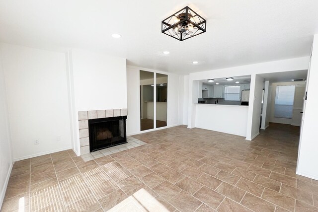 unfurnished living room with a tiled fireplace