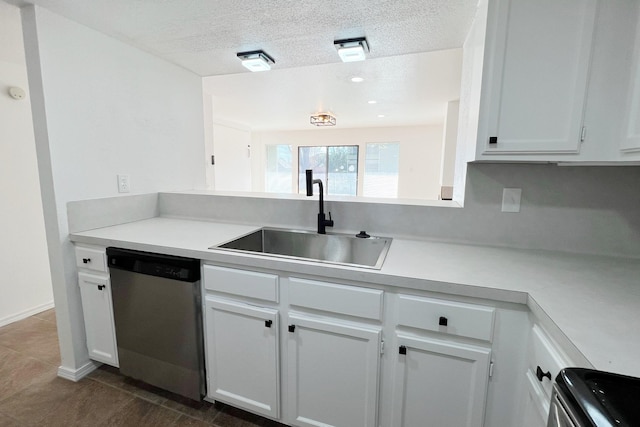 kitchen with a textured ceiling, stainless steel dishwasher, white cabinets, and sink