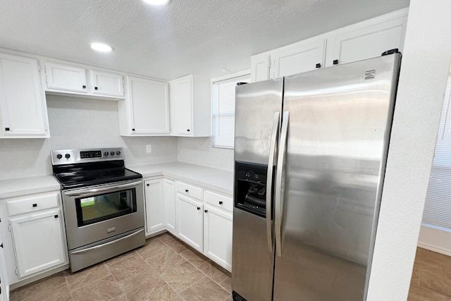 kitchen featuring a textured ceiling, white cabinets, and stainless steel appliances