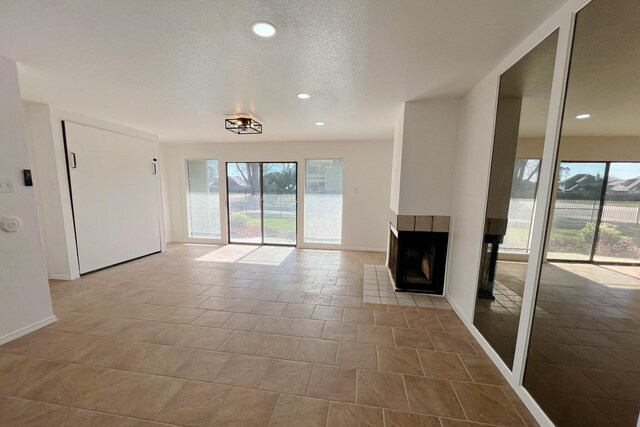 unfurnished living room featuring a textured ceiling and a tile fireplace