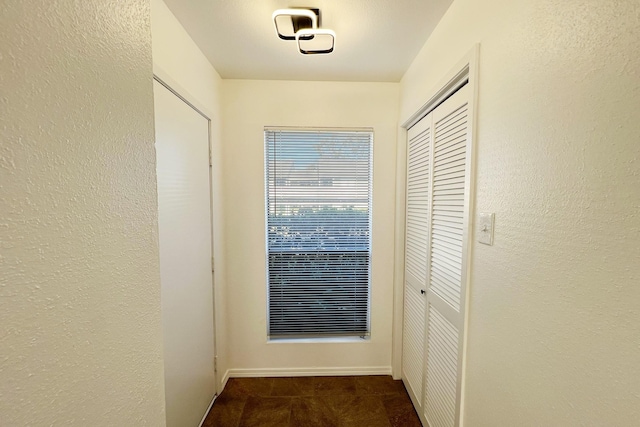 corridor with dark colored carpet