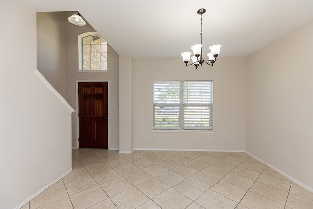 tiled foyer entrance featuring a chandelier