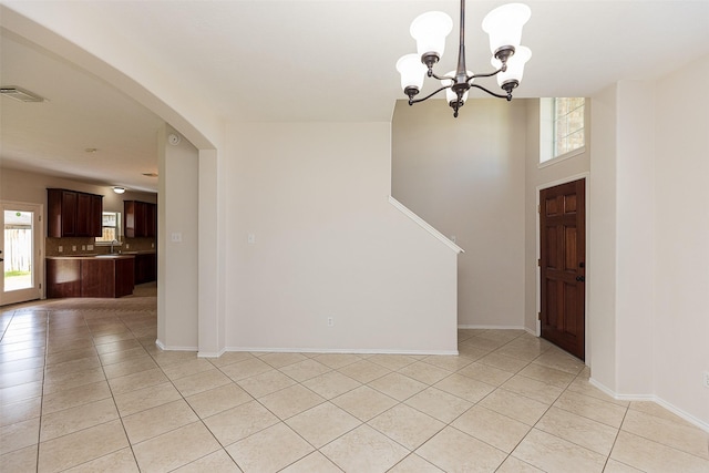 foyer featuring light tile patterned flooring, sink, and an inviting chandelier