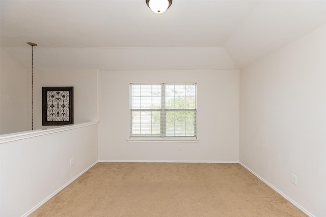 carpeted empty room with lofted ceiling