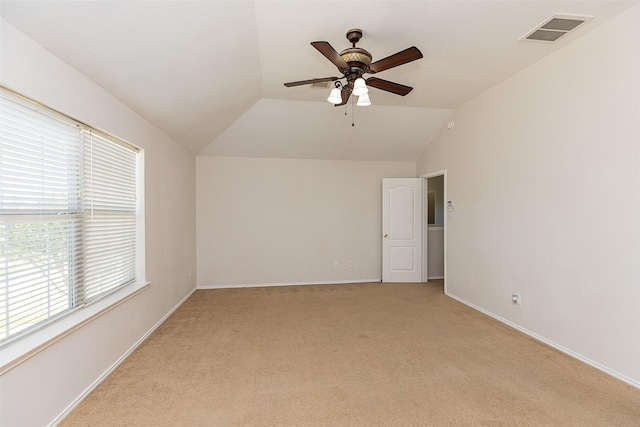 carpeted spare room with lofted ceiling and ceiling fan