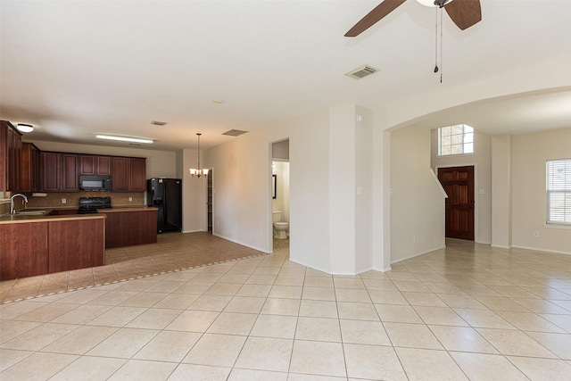 kitchen with black appliances, sink, decorative backsplash, light tile patterned floors, and kitchen peninsula