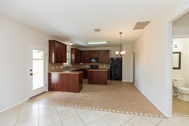 kitchen with sink, an inviting chandelier, a center island, hanging light fixtures, and black appliances