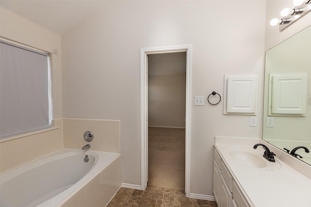 bathroom featuring vanity, vaulted ceiling, and a bath