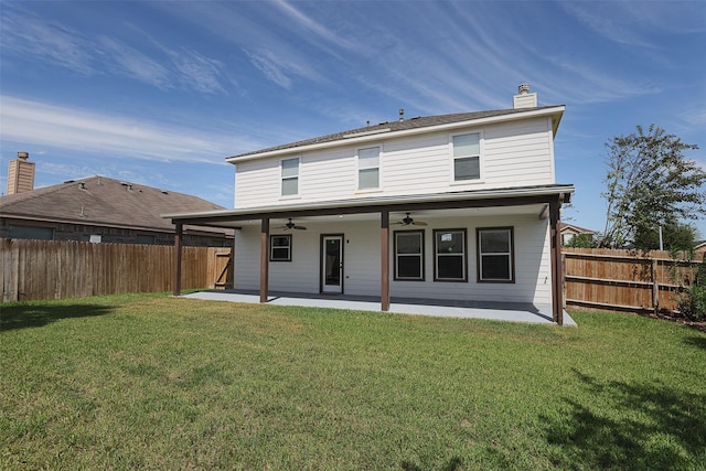 back of property with ceiling fan, a yard, and a patio area