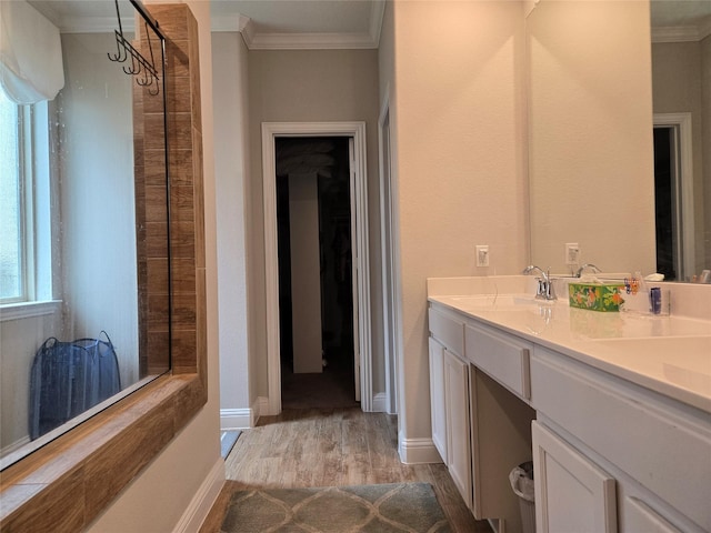 bathroom with hardwood / wood-style flooring, ornamental molding, and vanity