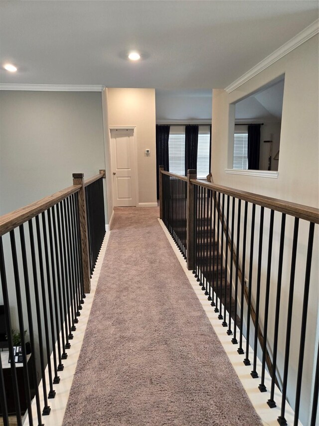 corridor featuring ornamental molding and light colored carpet