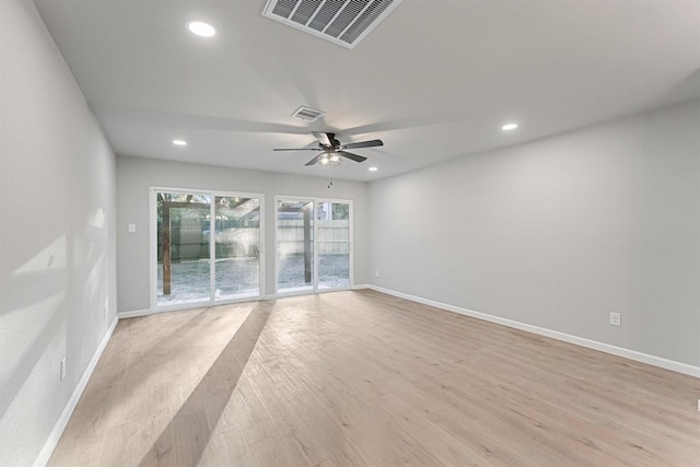 empty room with ceiling fan and light hardwood / wood-style flooring