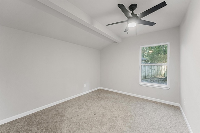 carpeted empty room featuring ceiling fan and lofted ceiling with beams