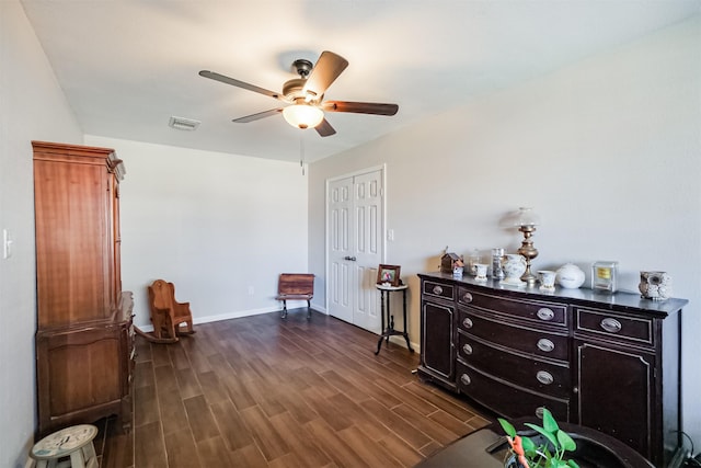 living area featuring dark hardwood / wood-style flooring and ceiling fan