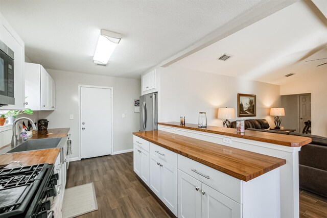 kitchen featuring appliances with stainless steel finishes, white cabinetry, and wood counters