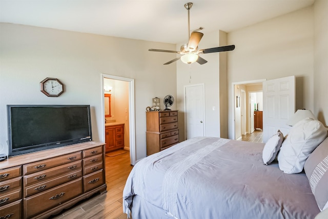 bedroom featuring ensuite bath, light wood-type flooring, and ceiling fan