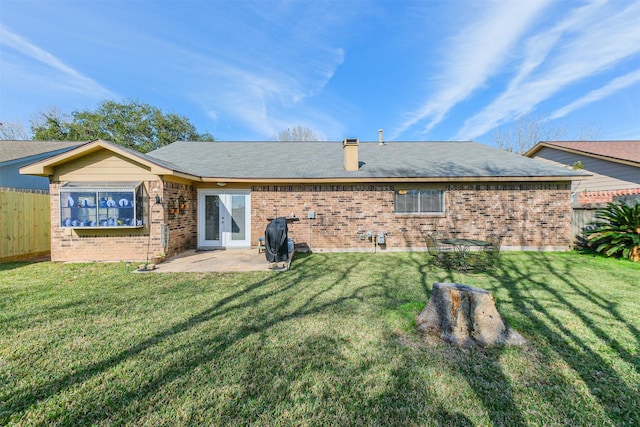 back of house featuring a patio area and a lawn