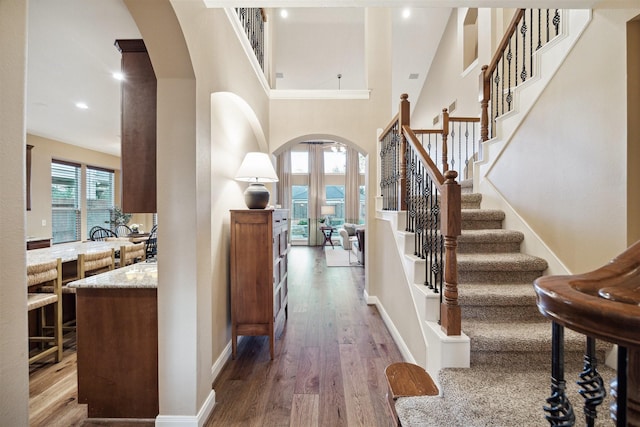 foyer entrance with a towering ceiling and hardwood / wood-style flooring