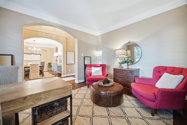 sitting room with a notable chandelier, ornamental molding, and light wood-type flooring