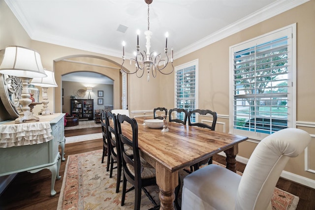 dining room featuring a healthy amount of sunlight, crown molding, a chandelier, and hardwood / wood-style flooring