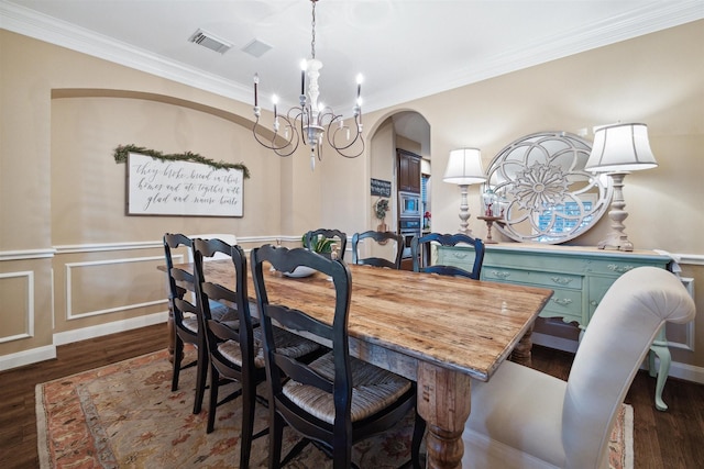 dining room with a notable chandelier, crown molding, and dark wood-type flooring