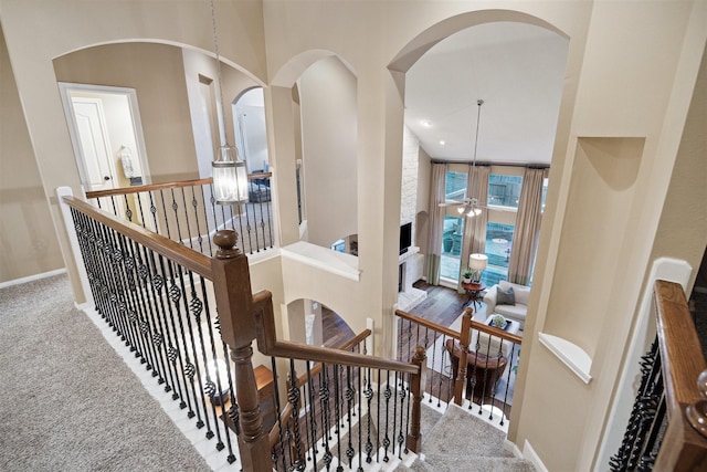 staircase with a high ceiling and carpet