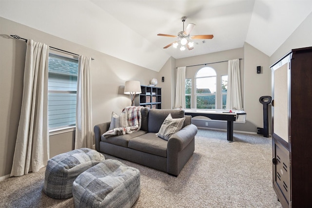 carpeted living room with ceiling fan and vaulted ceiling