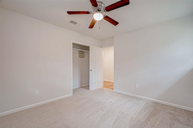 unfurnished bedroom featuring ceiling fan, a closet, and light carpet